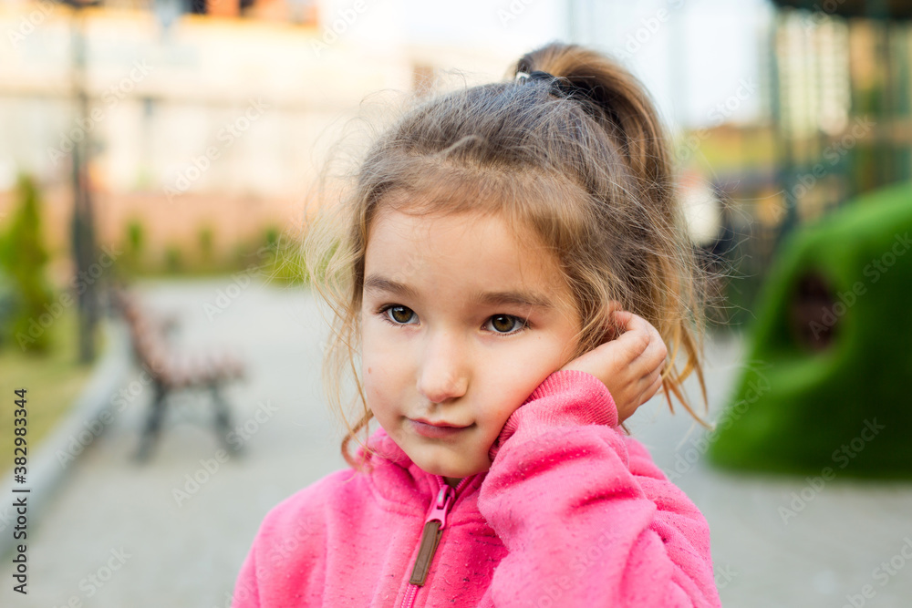 A little girl with a sad and frightened face holds her cheek with her hand - a tooth hurts. Ear pain, toothache, swollen cheek and gums, problems of pediatric dentistry, otolaryngology. Child medicine A little girl with a sad and frightened face holds her cheek with her hand - a tooth hurts. Ear pain, toothache, swollen cheek and gums, problems of pediatric dentistry, otolaryngology. Child medicine