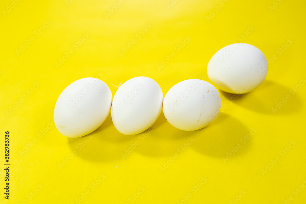 five eggs on vibrant yellow background