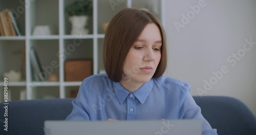 Thoughtful serious young woman student writer sit at home office desk with laptop thinking of inspiration search problem solution ideas lost in thoughts concept dreaming looking away