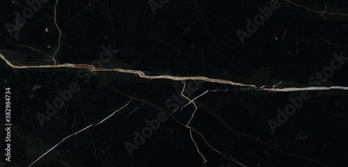 Luxurious black agate marble texture with golden veins, polished marble quartz stone background striped by nature with a unique patterning, natural breccia marble for ceramic wall and floor tiles.