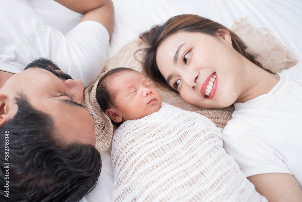smiling mother and father holding their newborn baby at home..portrait of happy family at home, young parents holding on hands little sweet newborn baby, love and happiness concept. smiling mother and father holding their newborn baby at home..portrait of happy family at home, young parents holding on hands little sweet newborn baby, love and happiness concept.
