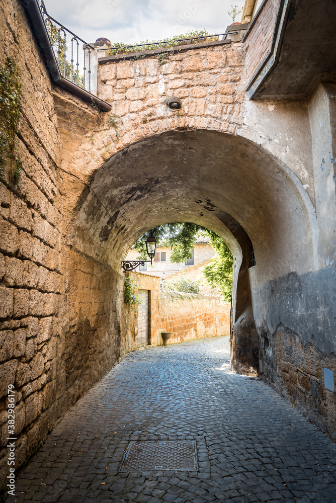 Narrow old street under the arch of the bridge in Orvieto, Umbria, Italy