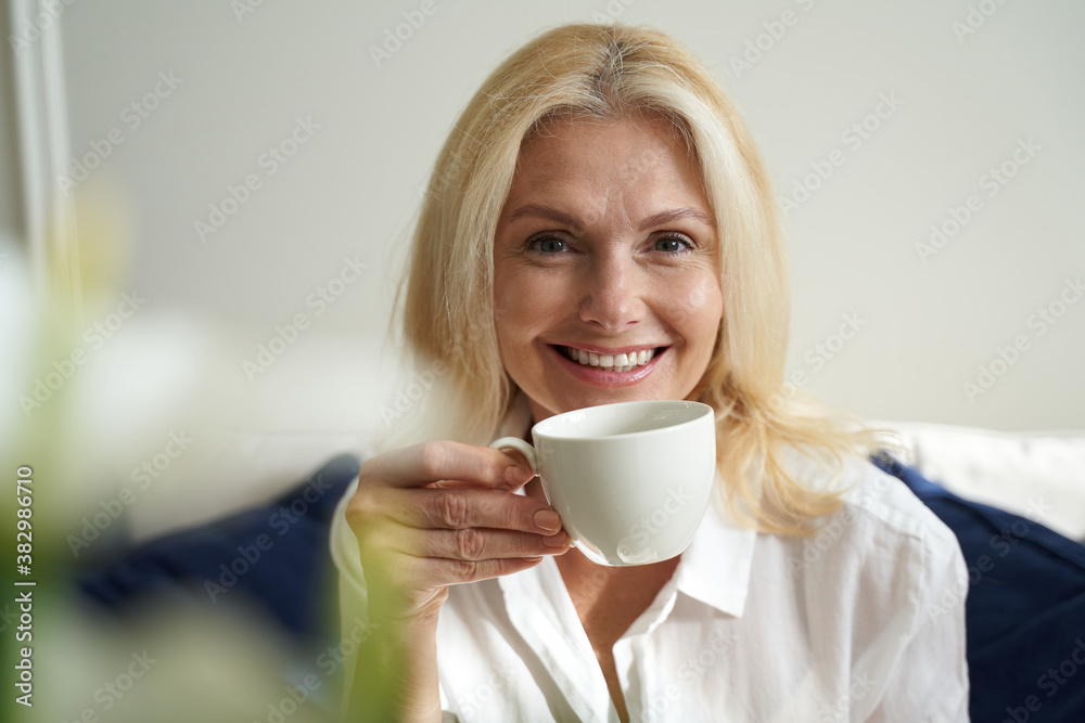Happy pretty woman is enjoying hot drink Happy pretty woman is enjoying hot drink