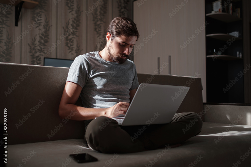 Remote Job. Man Working On Laptop Sitting On Sofa At Home. Remote Job. Man Working On Laptop Sitting On Sofa At Home.