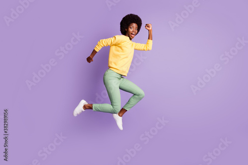 Full length profile side photo of crazy afro american girl jump run copyspace isolated over purple color background