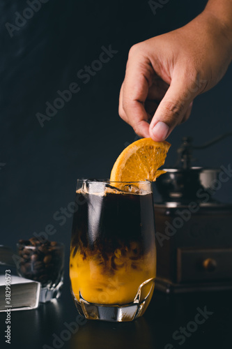 Orange and coffee cocktail on the black background. Shallow depth of field.