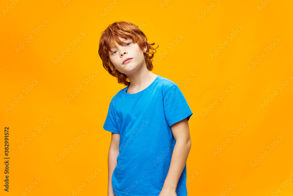 redhead boy head tilted to one side blue t-shirt studio yellow redhead boy head tilted to one side blue t-shirt studio yellow