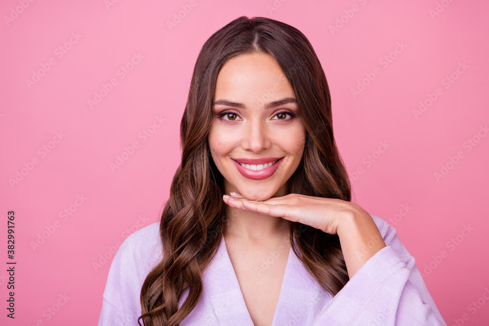 Closeup photo of beautiful lady long curly hairstyle spa salon procedures touch arm chin demonstrating perfect facial skin condition wear bathrobe isolated pastel pink color background Closeup photo of beautiful lady long curly hairstyle spa salon procedures touch arm chin demonstrating perfect facial skin condition wear bathrobe isolated pastel pink color background