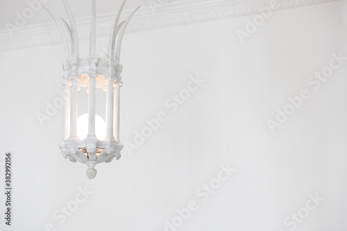 close up view of white vintage stone lantern or lamp hanging from ceiling