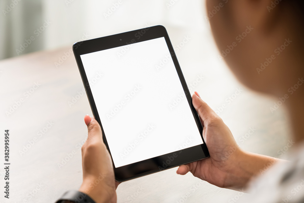 Young woman holding digital tablet with a blank screen on table, for putting advertising to promote.