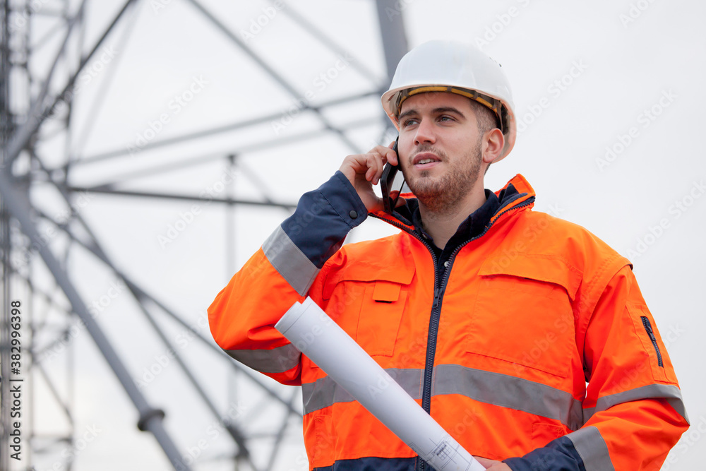 Young engineer or foreman talking on smart phone on a oil platform or construction site Young engineer or foreman talking on smart phone on a oil platform or construction site
