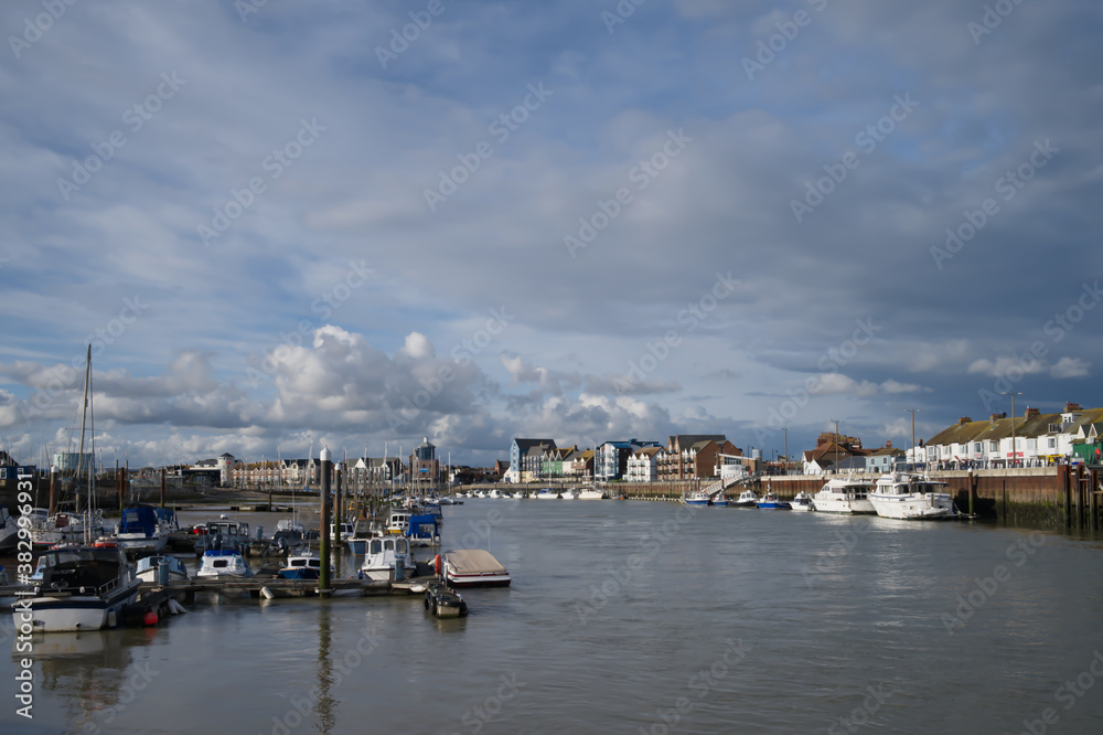 Dramatic stormy skies over the River Arun in Littlehampton with cumulus clouds.
