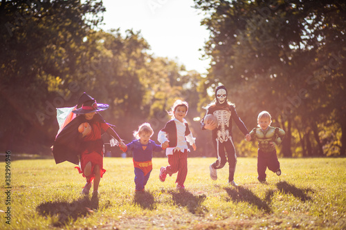 Children in Halloween suits run through the park.