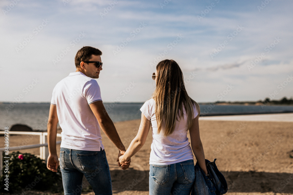 Close up of romantic couple hold hands and walk on the beach Close up of romantic couple hold hands and walk on the beach