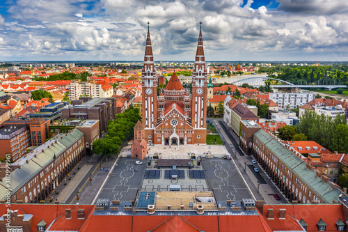 Szeged, Hungary - Aerial drone view of the Votive Church and Cathedral of Our Lady of Hungary (Szeged Dom) on a sunny summer day with Inner Town Bridge (Belvarosi hid) and blue sky and clouds photo