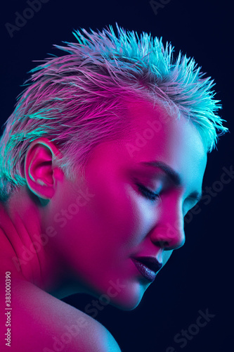 Inspiration. Portrait of female fashion model in neon light on dark studio background. Beautiful caucasian woman with trendy make-up and well-kept skin. Vivid style, beauty concept. Close up