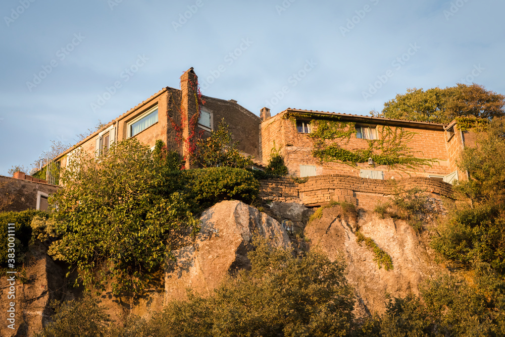 Houses on the rock illuminated by the dawn sun in the town of Calcata, Italy