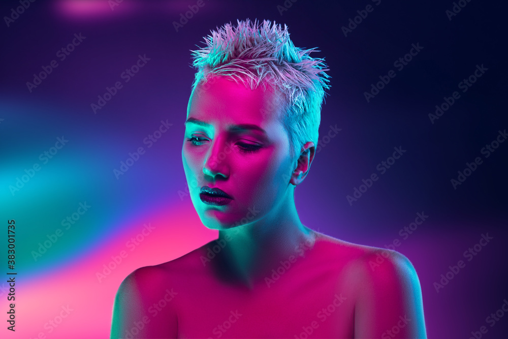 Shiny. Portrait of female fashion model in neon light on dark studio background. Beautiful caucasian woman with trendy make-up and well-kept skin. Vivid style, beauty concept. Close up. Copyspace Shiny. Portrait of female fashion model in neon light on dark studio background. Beautiful caucasian woman with trendy make-up and well-kept skin. Vivid style, beauty concept. Close up. Copyspace