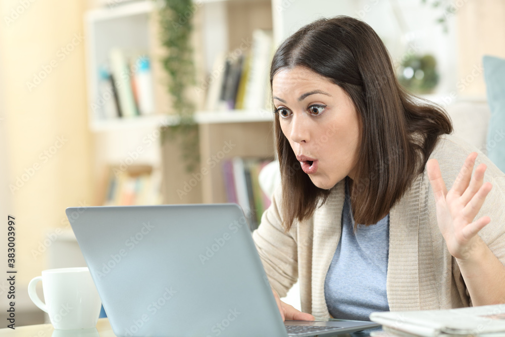 Amazed woman checking good news on laptop at home Amazed woman checking good news on laptop at home