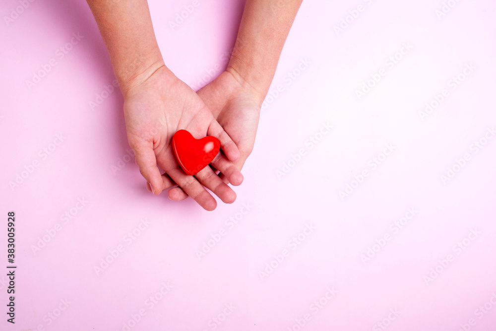 Two hands are holding a heart on a pink background. Flatley style Two hands are holding a heart on a pink background. Flatley style