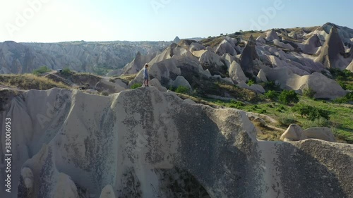 Male traveler taking in view of Cappadocia landscape, aerial circle shot photo