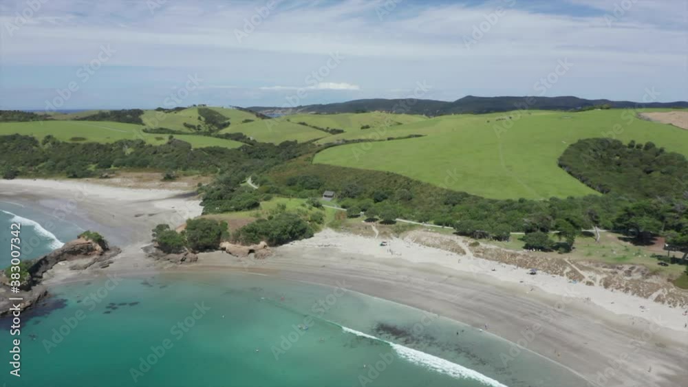 Stunning Landscape Of Tawharanui Regional Park With Lush Mountains Hills, Meadow, And Trees By The Turquoise Water Of Pacific Ocean In Auckland, New Zealand. - aerial arc shot Stunning Landscape Of Tawharanui Regional Park With Lush Mountains Hills, Meadow, And Trees By The Turquoise Water Of Pacific Ocean In Auckland, New Zealand. - aerial arc shot