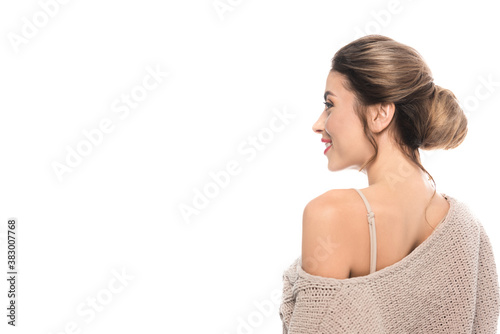 sensual woman in knitted sweater looking away while posing isolated on white