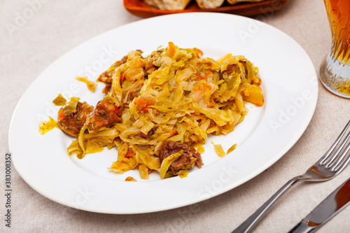 Delicious meat dish - pork with stewed cabbage served on plate. High quality photo