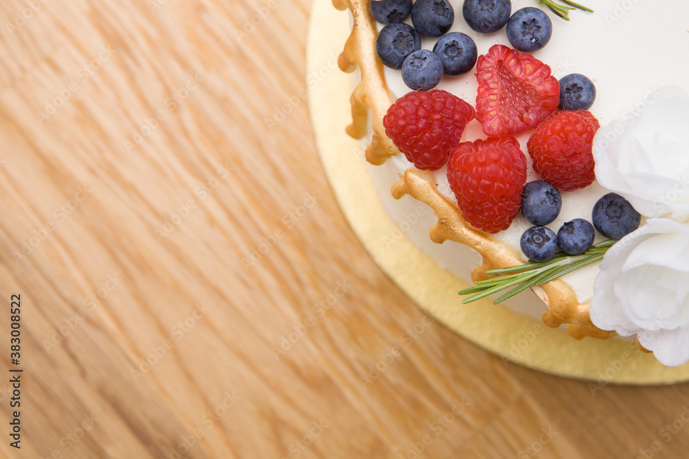 Delicious raspberry cake with fresh blueberries, raspberries, on a wooden background. Copy space. Banner