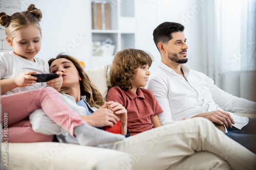 Family with kids sitting on sofa