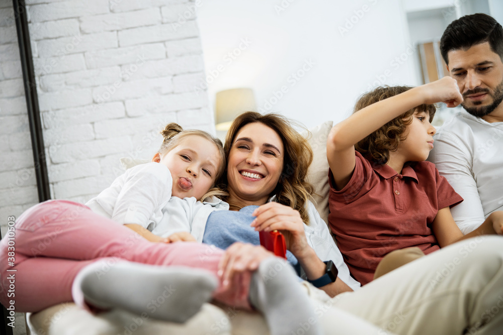 Family fooling around while sitting on the couch