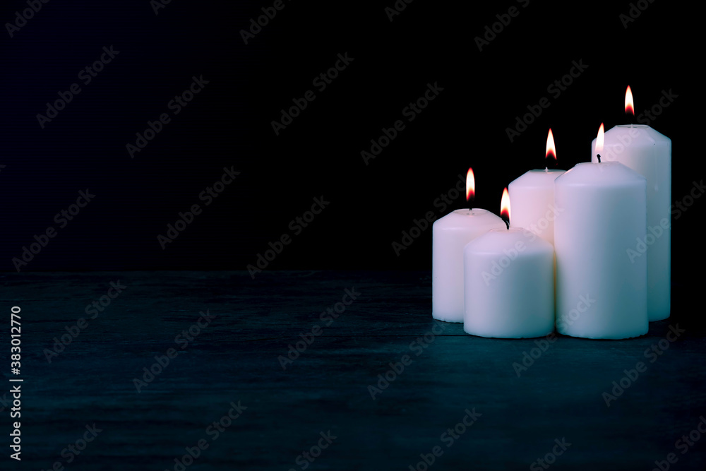 the candlelight of the big white candles group on a vintage wooden table the candlelight of the big white candles group on a vintage wooden table