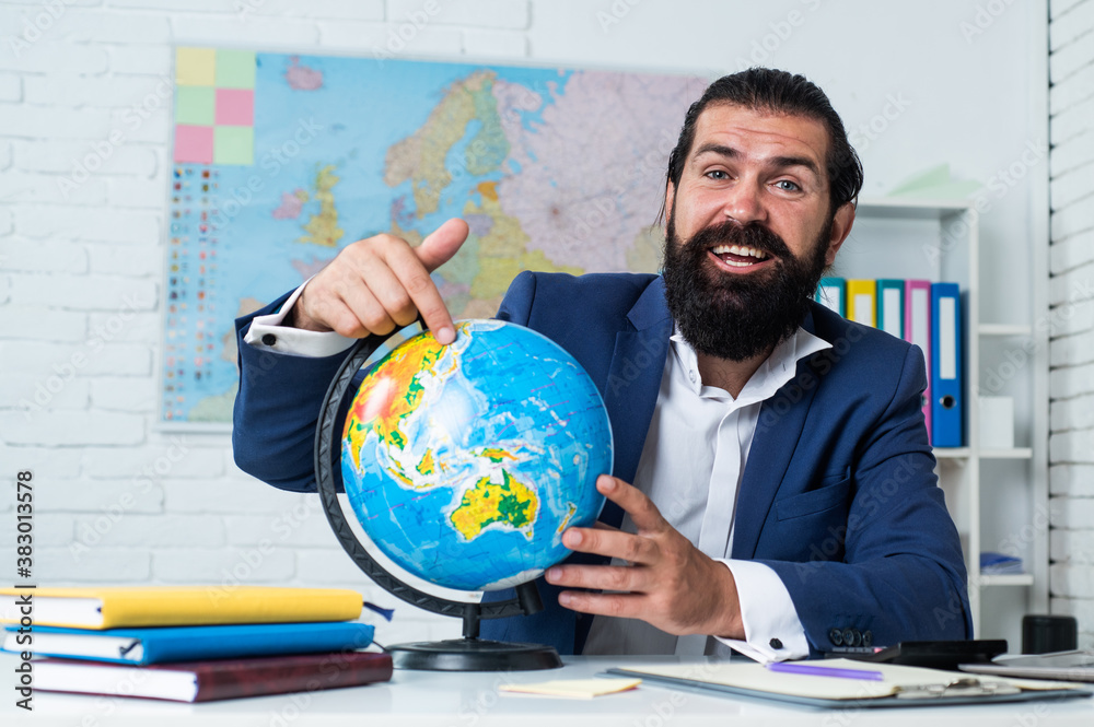 geography studying. informal education. male student sit in school classroom with map. pass the exam. learning the subject. geographer. happy man with beard pointing at globe geography studying. informal education. male student sit in school classroom with map. pass the exam. learning the subject. geographer. happy man with beard pointing at globe