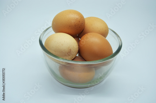 a bowl of fresh chicken eggs with a unique shell color texture, with a white backgrund 