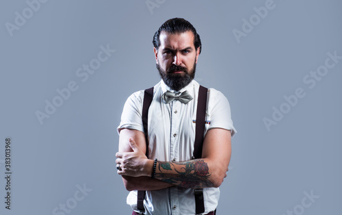 mature male hipster wear suspenders and bow tie has well groomed hair and beard, fashion and hairdresser photo