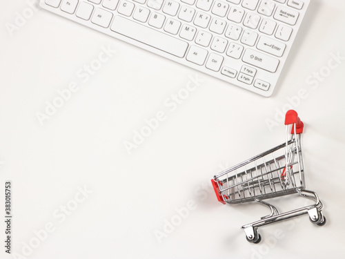 flat lay of computer keyboard with shopping cart on white background with copy space.Shopping online concept.
