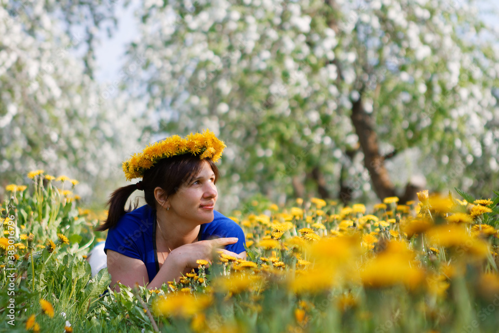 woman in apple orchard in blossom and dandelion field woman in apple orchard in blossom and dandelion field