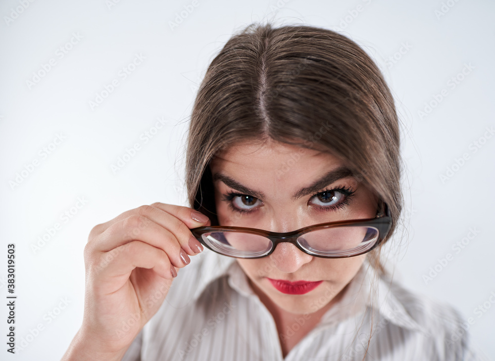 Mistrustful businesswoman looking over spectacles