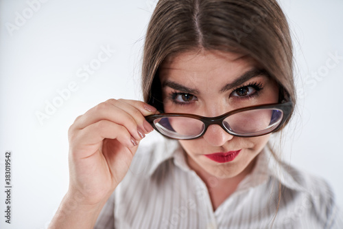 Mistrustful businesswoman looking over spectacles