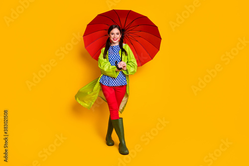 Full length body size view of her she nice attractive fashionable cheerful cheery content girl wearing green coat open parasol strolling isolated bright vivid shine vibrant yellow color background