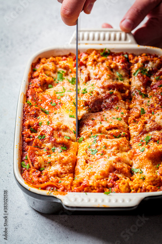 Traditional Italian baked lasagne with meat and cheese in the dish. Italian cuisine concept.