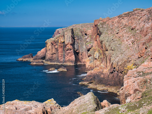 Red granite cliffs on Muckle Roe, Shetland, UK - these rocks are of the Muckle Roe Intrusion - granite, granophyric - igneous bedrock formed 359 to 383 million years ago in the Devonian Period.