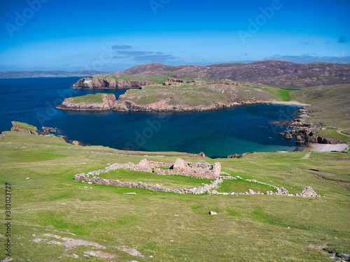 With an abandoned, derelict croft in the foreground, the deserted, tranquil coastal inlet of South Ham on the island of Muckle Roe in Shetland, Scotland, UK