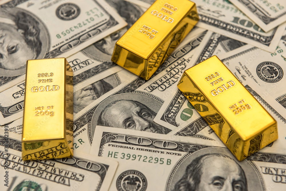  gold bars bullions lying on 100 dollar bills