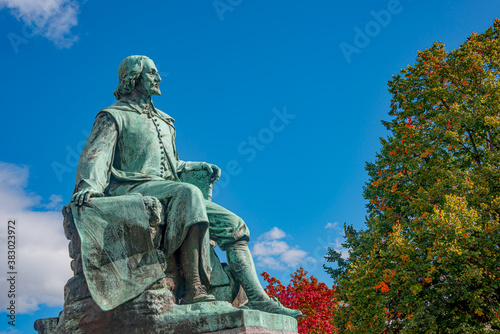 Statue of great scientist Otto von Guericke in red and golden Autumn colors in historical downtown of Magdeburg Germany, at sunny day and blue sky, closeup, details..