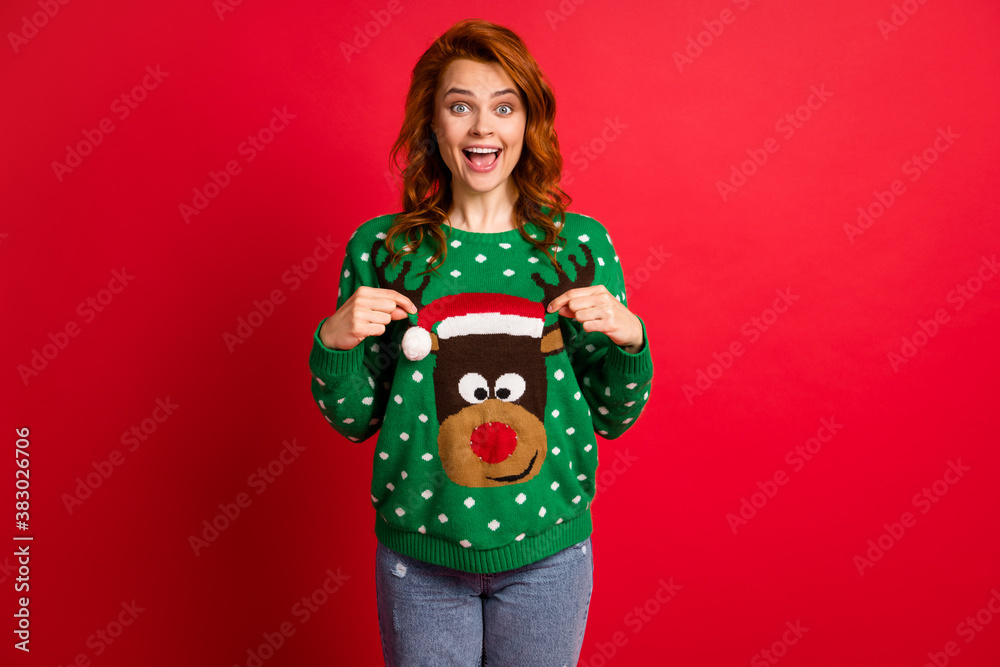 Photo portrait of excited girl with open mouth pointing two fingers at ugly sweater isolated on vivid red colored background Photo portrait of excited girl with open mouth pointing two fingers at ugly sweater isolated on vivid red colored background