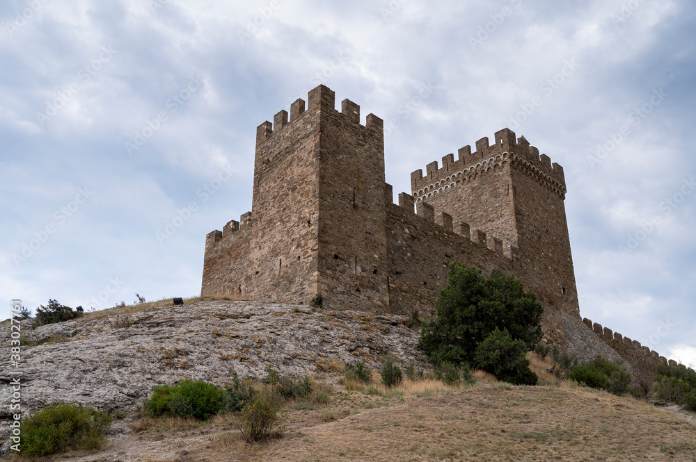 old castle in the mountains against the blue sky, old tower of a defensive fortress