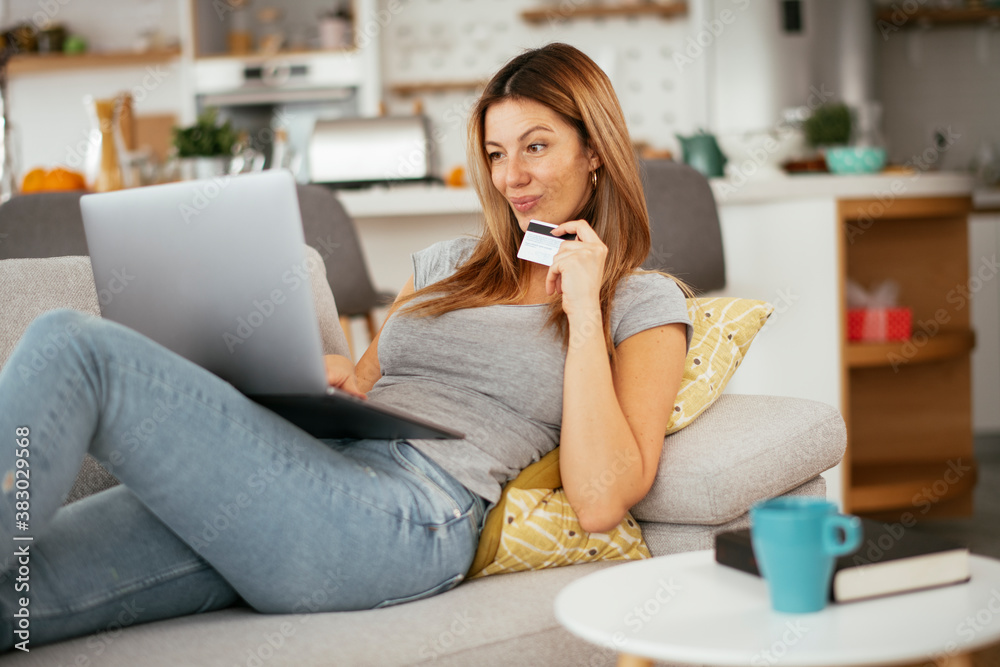 Young businesswoman at home makes a purchase on the Internet. Beautiiful woman on the laptop with credit card.. Young businesswoman at home makes a purchase on the Internet. Beautiiful woman on the laptop with credit card..