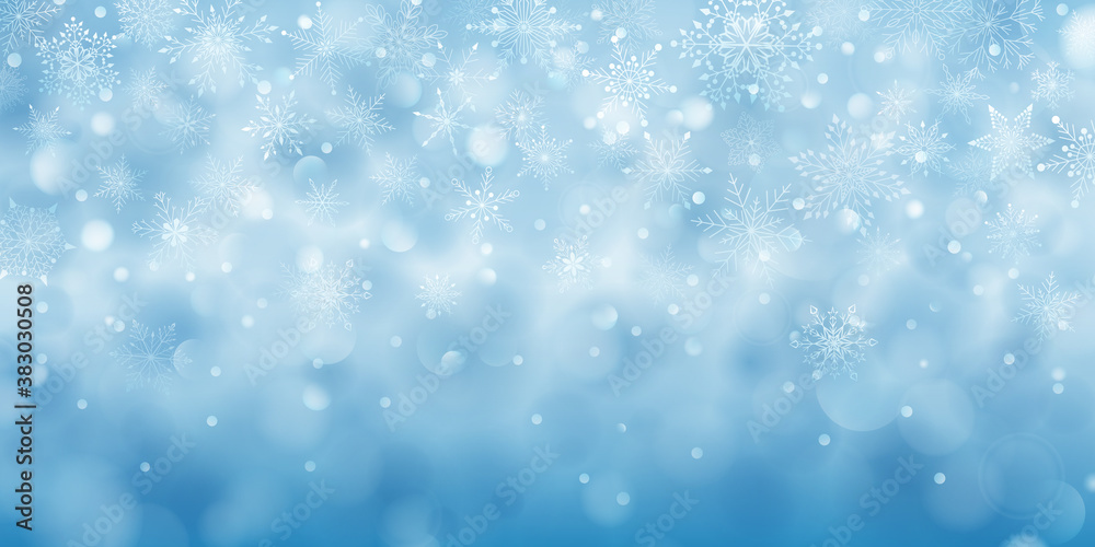 Christmas background of complex big and small falling snowflakes in light blue colors with bokeh effect