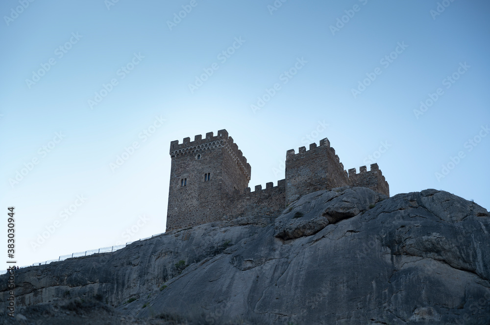 old castle in the mountains against the blue sky, old tower of a defensive fortress
